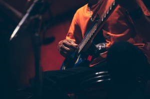 man hand playing guitar acoustic and singing on the stage at night.